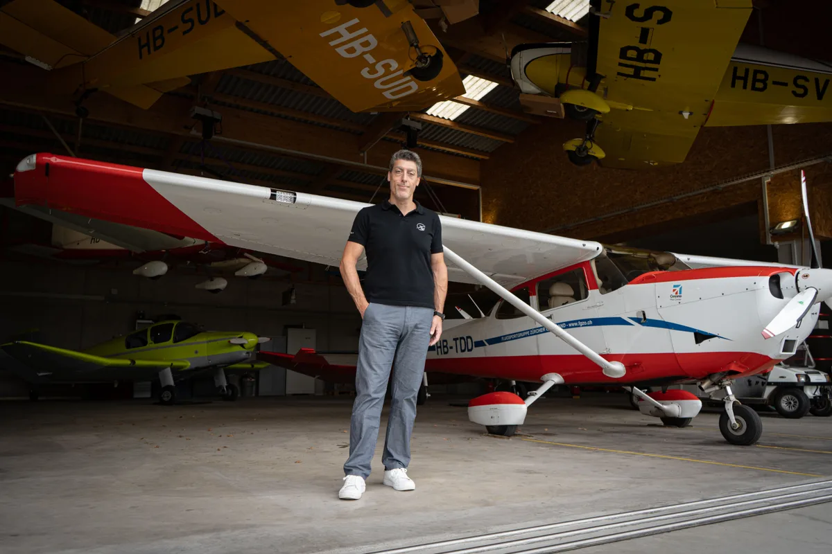 Ein Mann steht vor einem Flugzeug in einem Hangar.